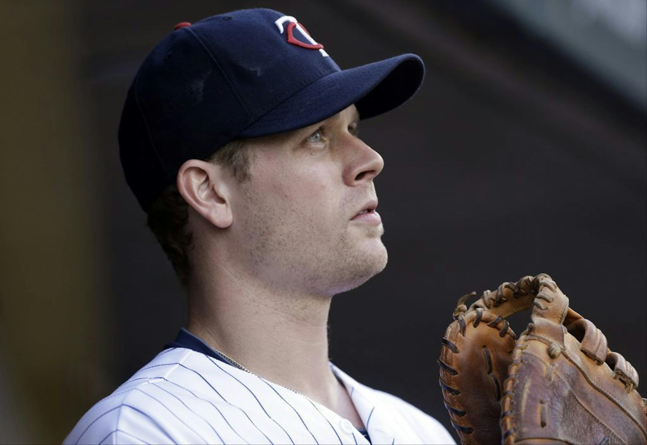 Minnesota Twins first baseman Justin Morneau watches game highlights before the first inning of a baseball against the against the Cleveland Indians game, Friday, July 19, 2013 in Minneapolis.