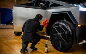 Chris Callahan, a Tesla Advisor, polishes a Tesla Cybertruck model during an Environmental Protection Agency event in Washington, on March 20, 2024. P