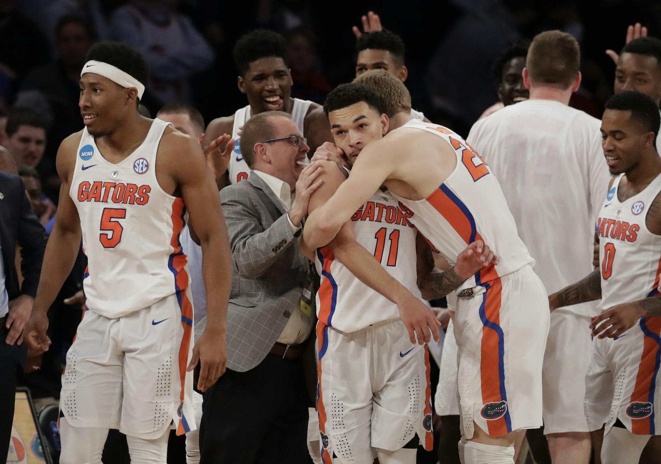 Florida players celebrate after a last second shot by guard Chris Chiozza (11) to beat Wisconsin in overtime of an East Regional semifinal game of the NCAA men's college basketball tournament, Saturday, March 25, 2017, in New York. Florida won 84-83. (AP Photo/Julio Cortez)