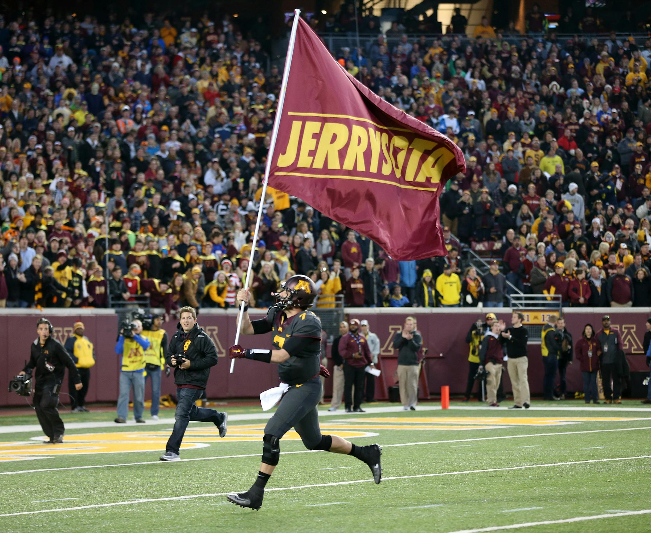 Mitch Leidner (7) waved a flag honoring Jerry Kill before kickoff at TCF Bank Stadium Saturday October 31, 2015