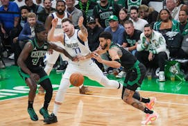 Dallas Mavericks guard Luka Doncic (77) loses the ball as Boston Celtics guard Jrue Holiday (4) and forward Jayson Tatum (0) defend during the first h