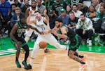 Dallas Mavericks guard Luka Doncic (77) loses the ball as Boston Celtics guard Jrue Holiday (4) and forward Jayson Tatum (0) defend during the first h