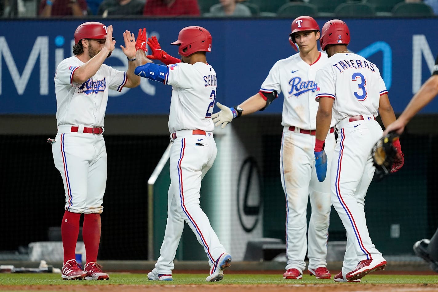 Charlie Culberson, Marcus Semien, Corey Seager, right rear, and Leody Taveras celebrate after Semien hit a three-run home run in the fourth inning Saturday