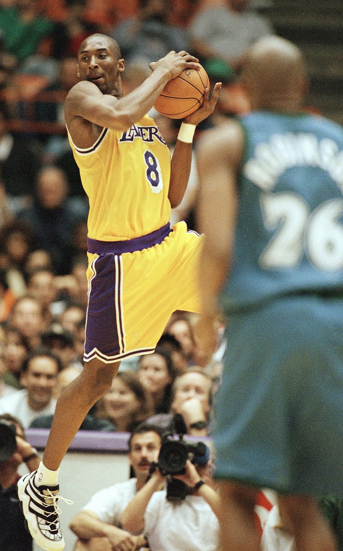 Los Angeles Lakers Kobe Bryant looks for a teammate to pass to as Minnesota Timberwolves James Robinson looks on during their game at the Forum in Inglewood, California on Sunday, Nov. 3, 1996. (AP Photo/Michael Caulfield) ORG XMIT: APHS260933