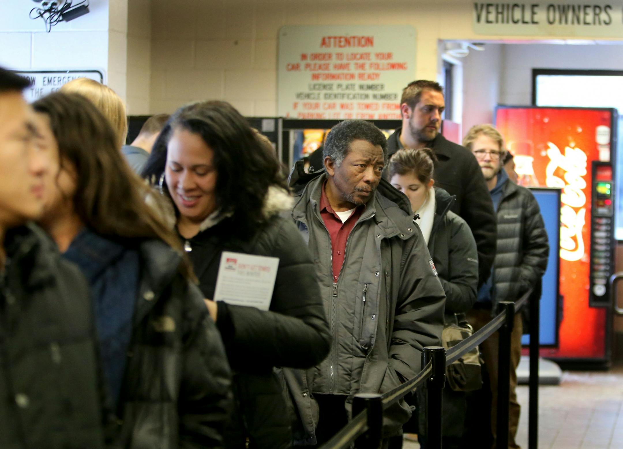 Unhappy car owners wait in line at the ciity of Minneapolis auto impound lot in order to reclaim their towed vehicles Wednesday, Dec. 30, 2015, in Minneapolis, MN.