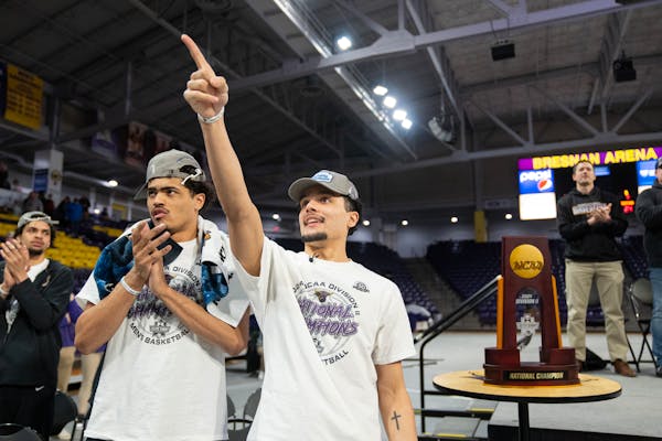 Minnesota State Mankato guards Kyreese and Malik Willingham, who are brothers, stand next to the DII National Championship trophy during a welcome hom