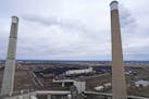 Stacks from three large steam turbine-generators, along with massive mounds of coal, can be seen from the roof of the Sherburne County Generating Stat