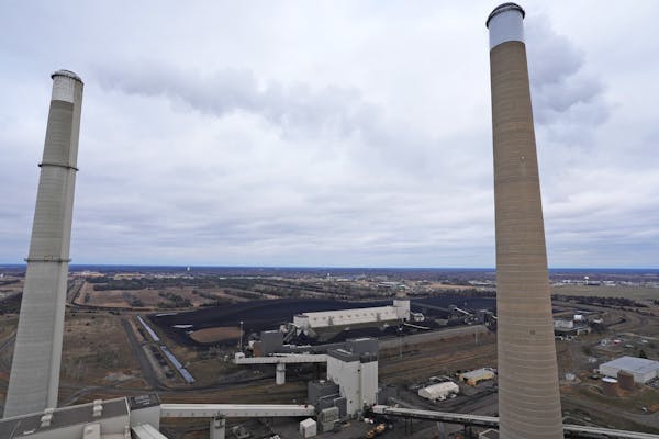 Stacks from three large steam turbine-generators, along with massive mounds of coal, can be seen from the roof of the Sherburne County Generating Stat