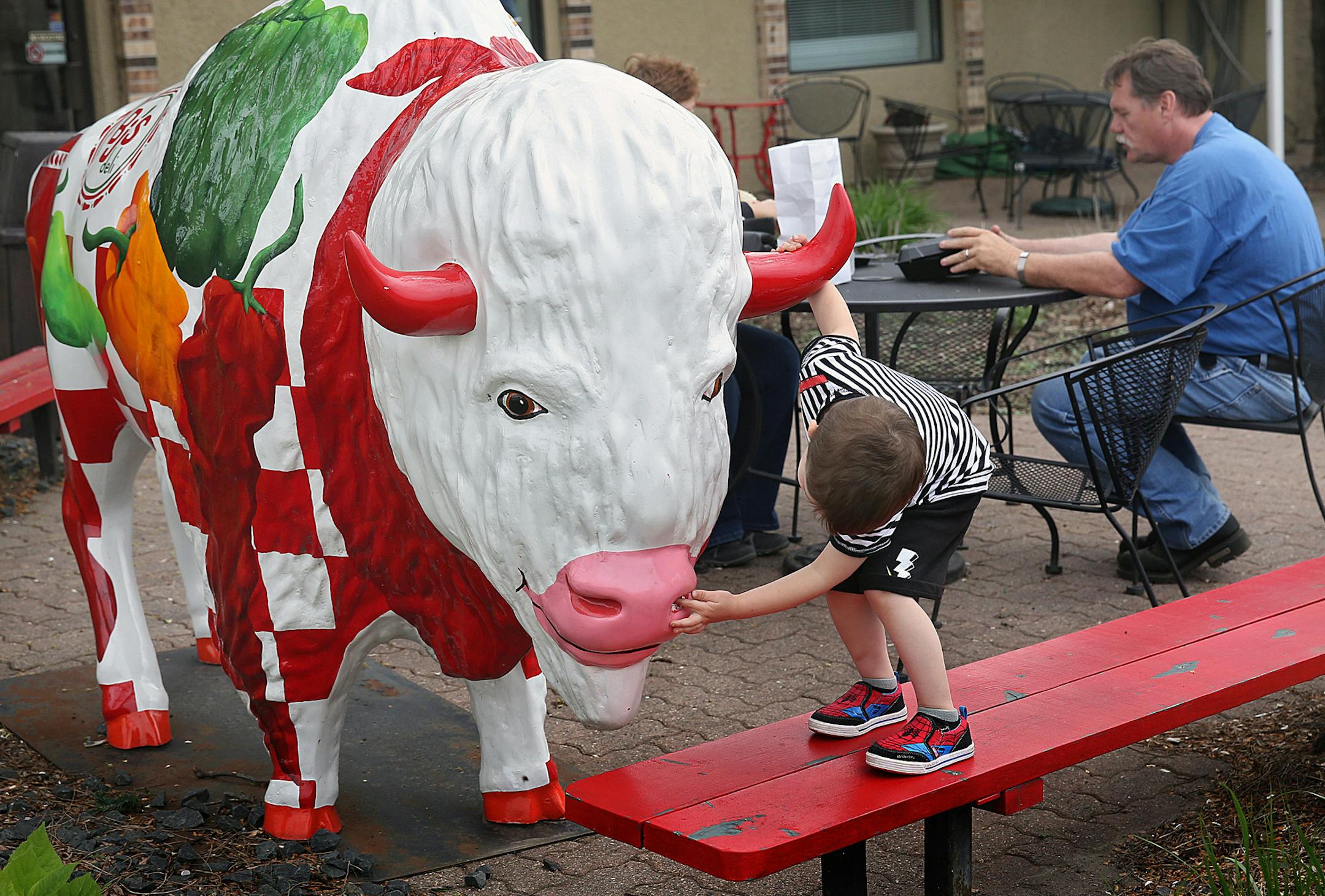 Arrow Hartman, 3, of Richfield, examined one of the many buffalo statues on display in Buffalo.