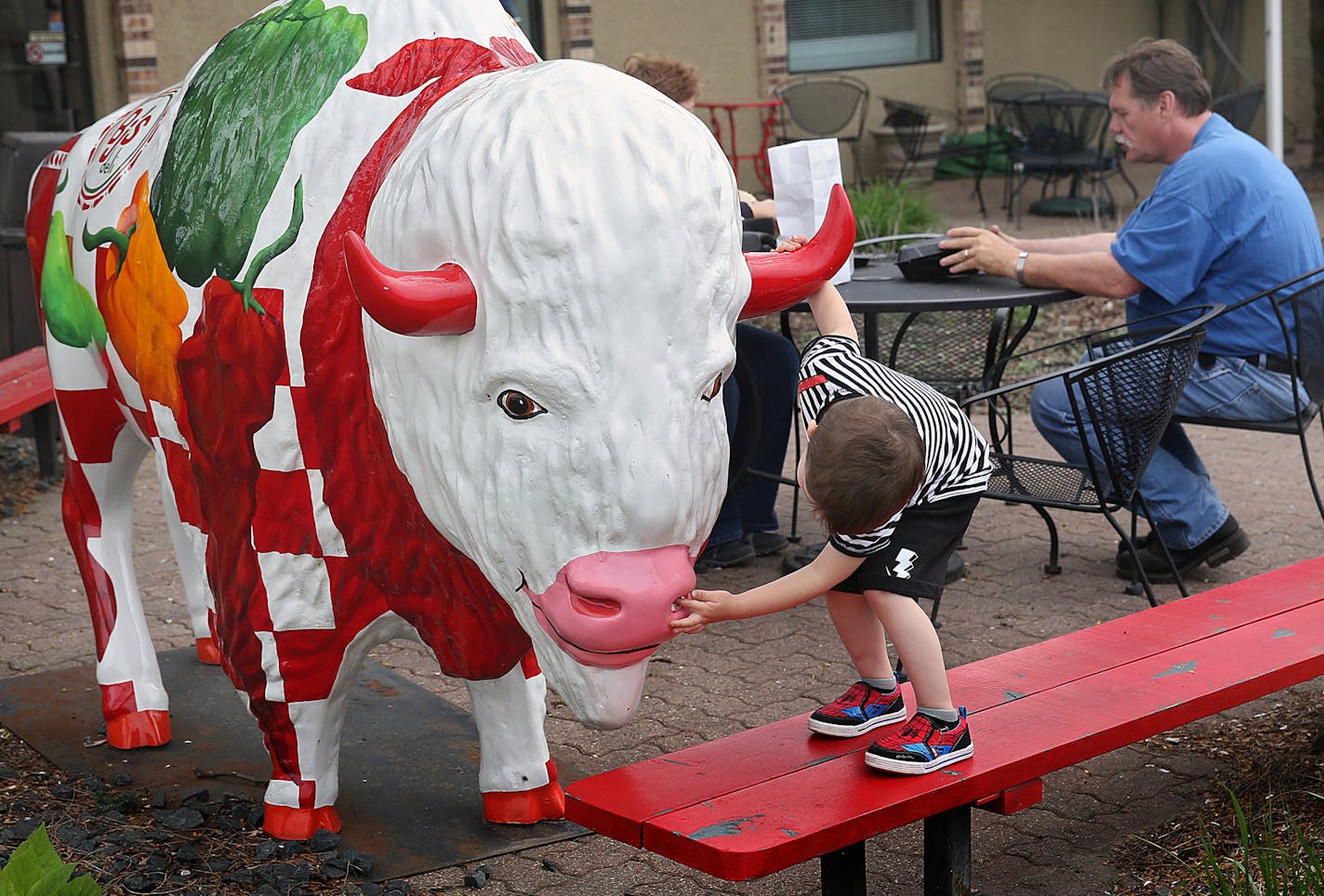 Arrow Hartman, 3, of Richfield, examined one of the many buffalo statues on display in Buffalo.