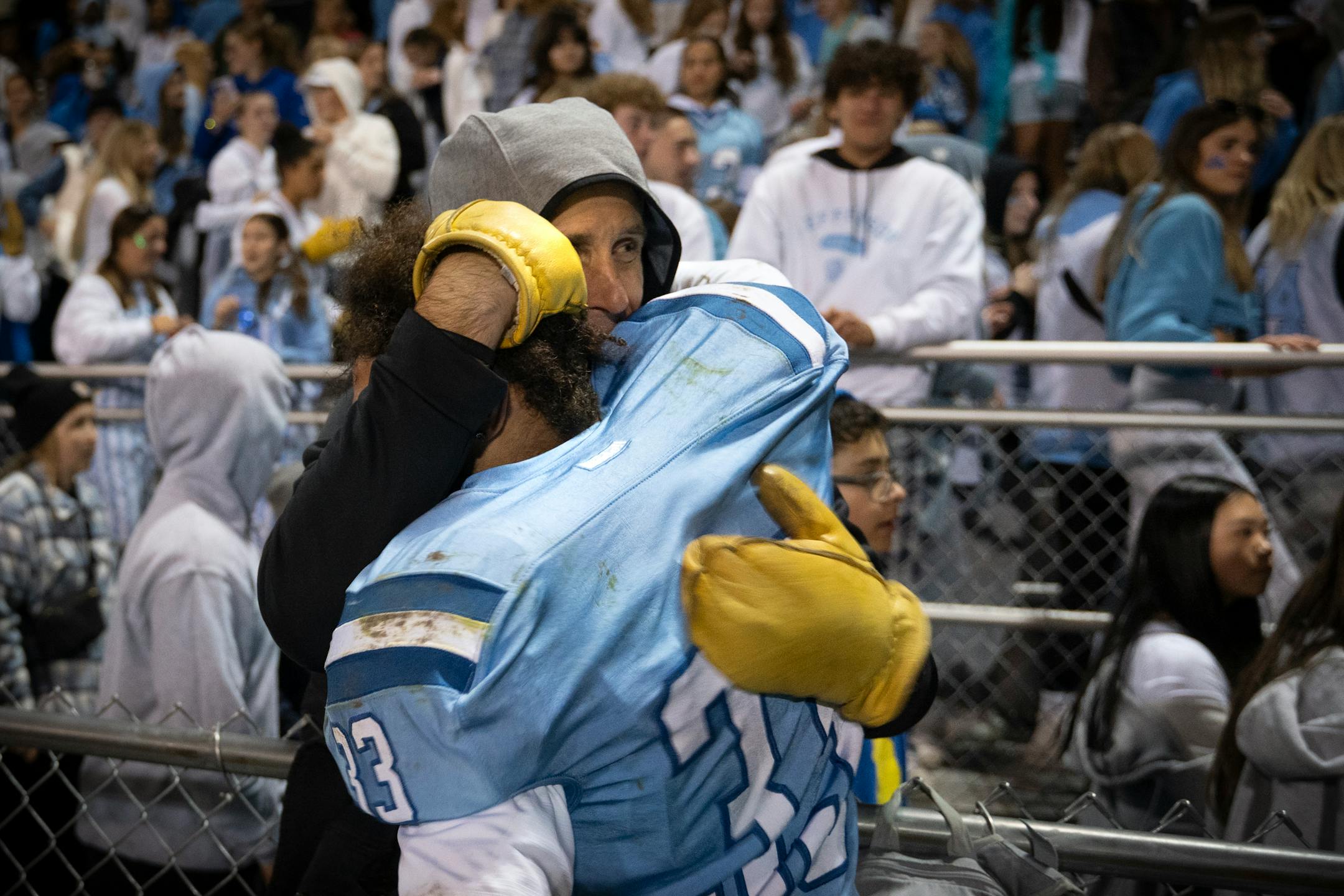 Bloomington Jefferson's Tevin Ekse (33) hugs a fan after his team's 34-20 win against the Robbinsdale Cooper.