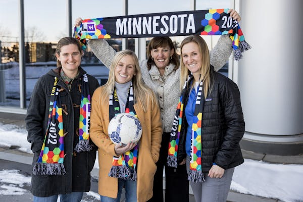 Aurora coaches, from left, Jen Larrick, head coach Nicole Lukic and Jennie Clark, with co-founder and president Andrea Yoch, holding their scarf.