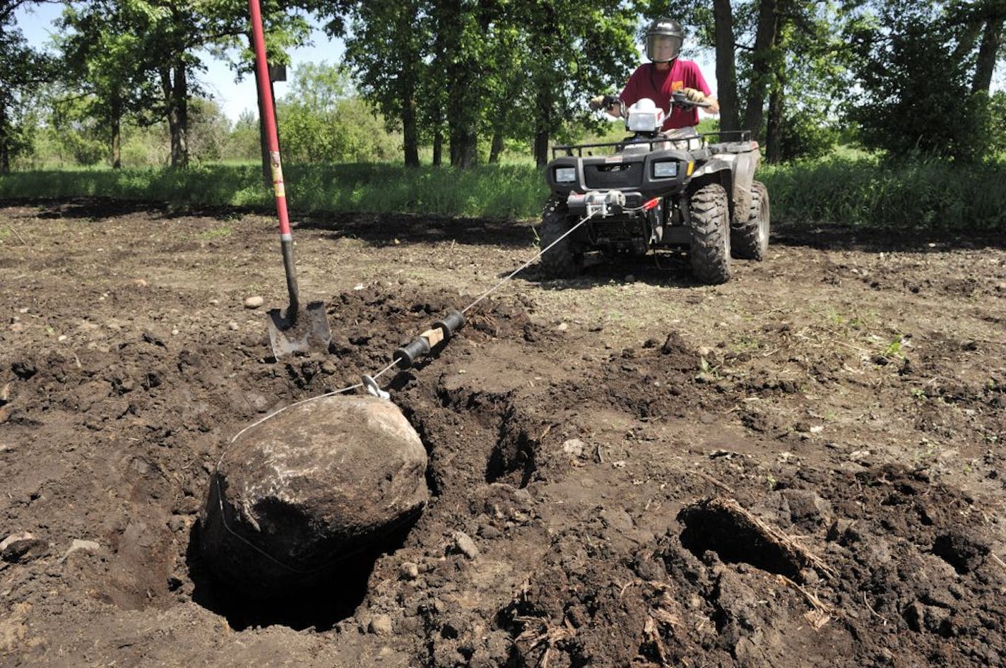 An ATV equipped with a winch, a shovel and bit of elbow grease can be successfully used to remove large rocks from a wildlife food plot.
