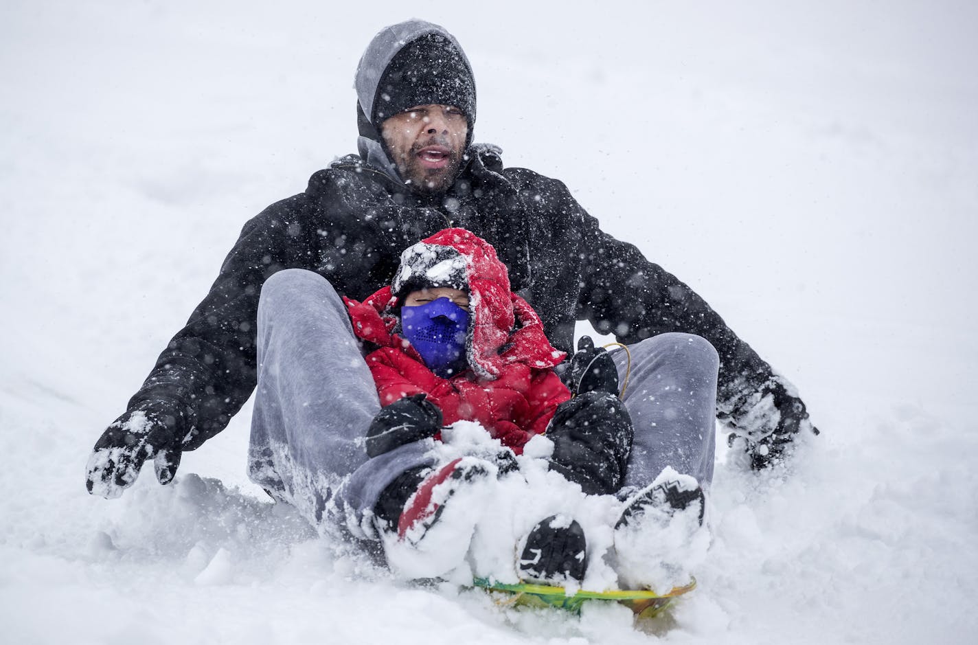 John Thomas and his son Gavin, 6, made way down a hill at Staring Lake Park in Eden Prairie during an April snow storm. ] CARLOS GONZALEZ &#x2022; cgonzalez@startribune.com &#x2013; Eden Prairie, MN &#x2013; April 12, 2020, Weather / Snow Feature