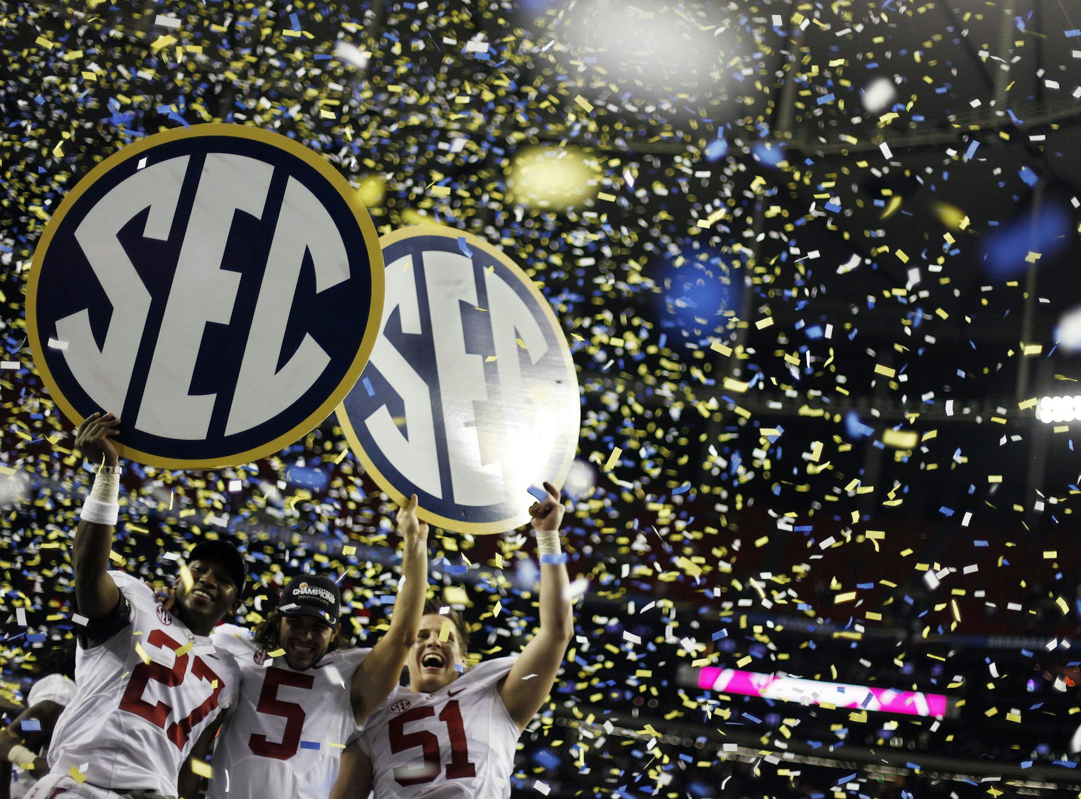 FILE - In this Dec. 1, 2012, file photo, Alabama players, from left, Nick Perry, Jeremy Shelley, and Carson Tinker celebrate after their 32-28 win in the Southeastern Conference championship NCAA college footbal game against Georgia, in Atlanta. The NCAA board of directors will vote Thursday, Aug. 7, 2014, on a proposal that would give the five wealthiest college football conferences the ability to make rules and pass legislation without the approval of the rest of Division I schools. (AP Photo/
