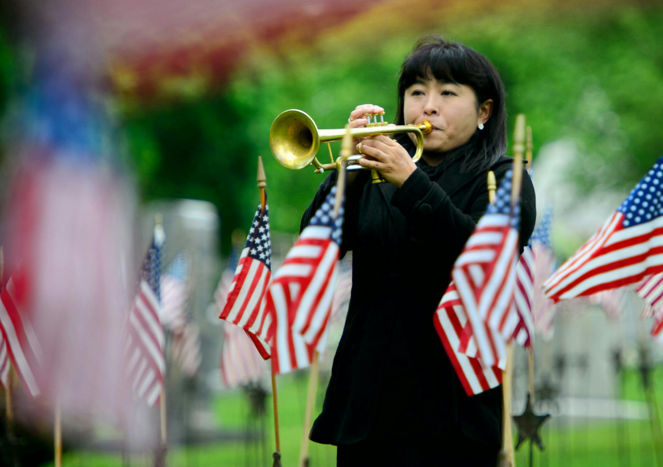 Trumpeter Takako Seimiya Senn played Taps at the conclusion of the ceremony. ] GLEN STUBBE * gstubbe@startribune.com , Monday, May 25, 2015 Traditional Memorial Day ceremony held near the Soldiers Memorial monument at Lakewood Cemetery, Minneapolis.