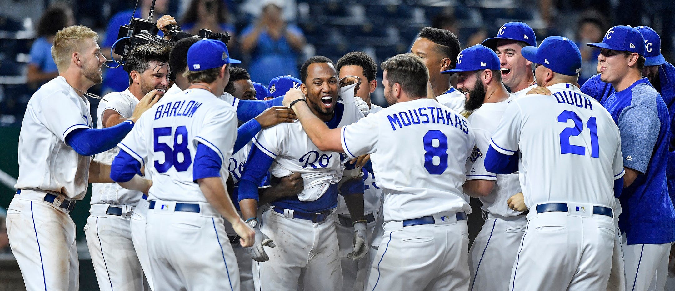 The Kansas City Royals' Alcides Escobar is surrounded by teammates after hitting the game-winning home run in the 14th inning against the Twins