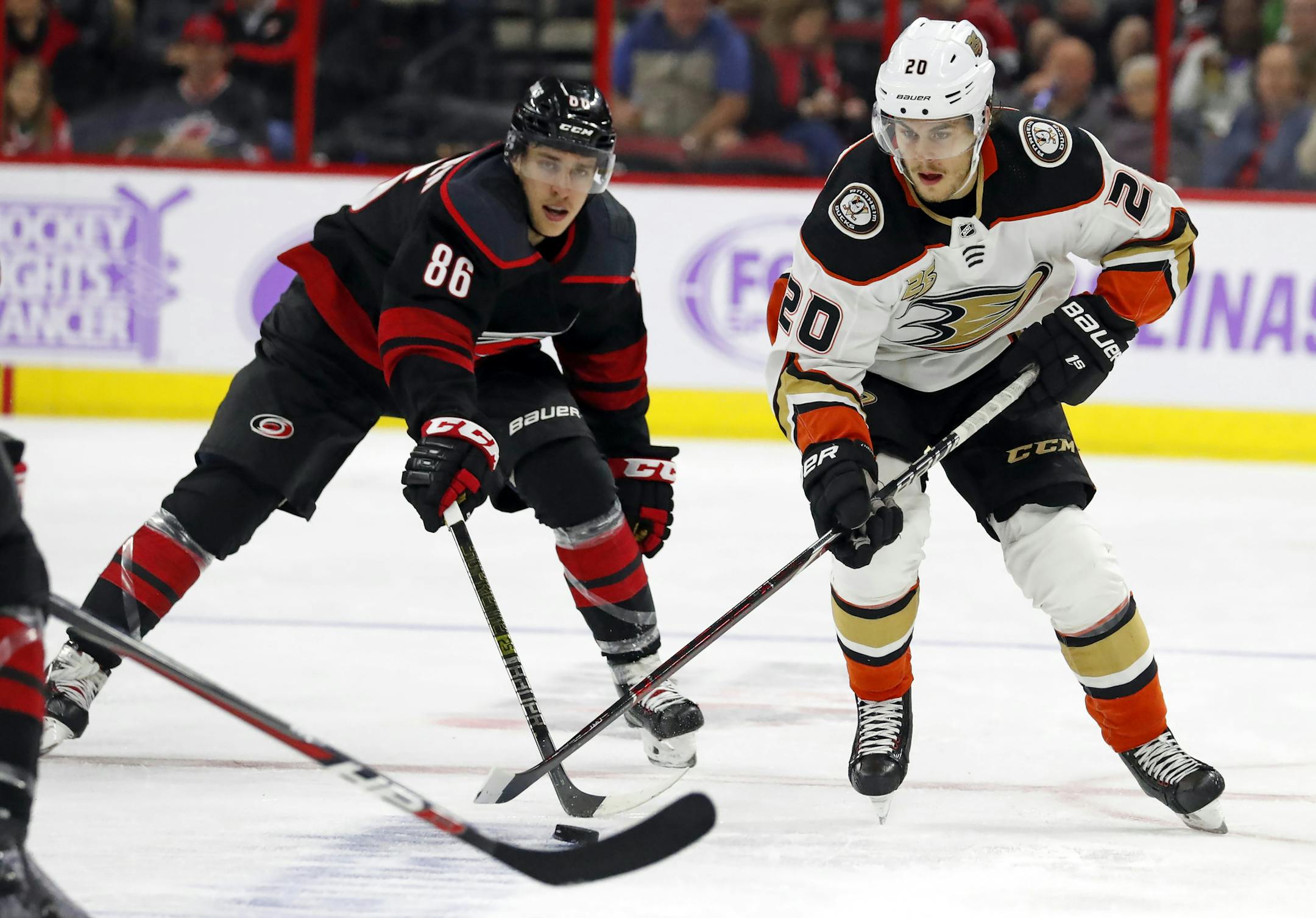 Anaheim Ducks' Pontus Aberg (20) battles with Carolina Hurricanes' Teuvo Teravainen (86) during the second period of an NHL hockey game, Friday, Nov. 30, 2018, in Raleigh, N.C. (AP Photo/Karl B DeBlaker)