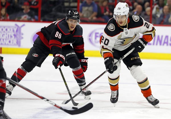 Anaheim Ducks' Pontus Aberg (20) battles with Carolina Hurricanes' Teuvo Teravainen (86) during the second period of an NHL hockey game, Friday, Nov. 
