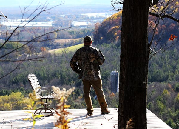 A Buffalo County landowner and deer hunter who asked not to be identified looks out over his hunting and forest land from an observation deck high abo