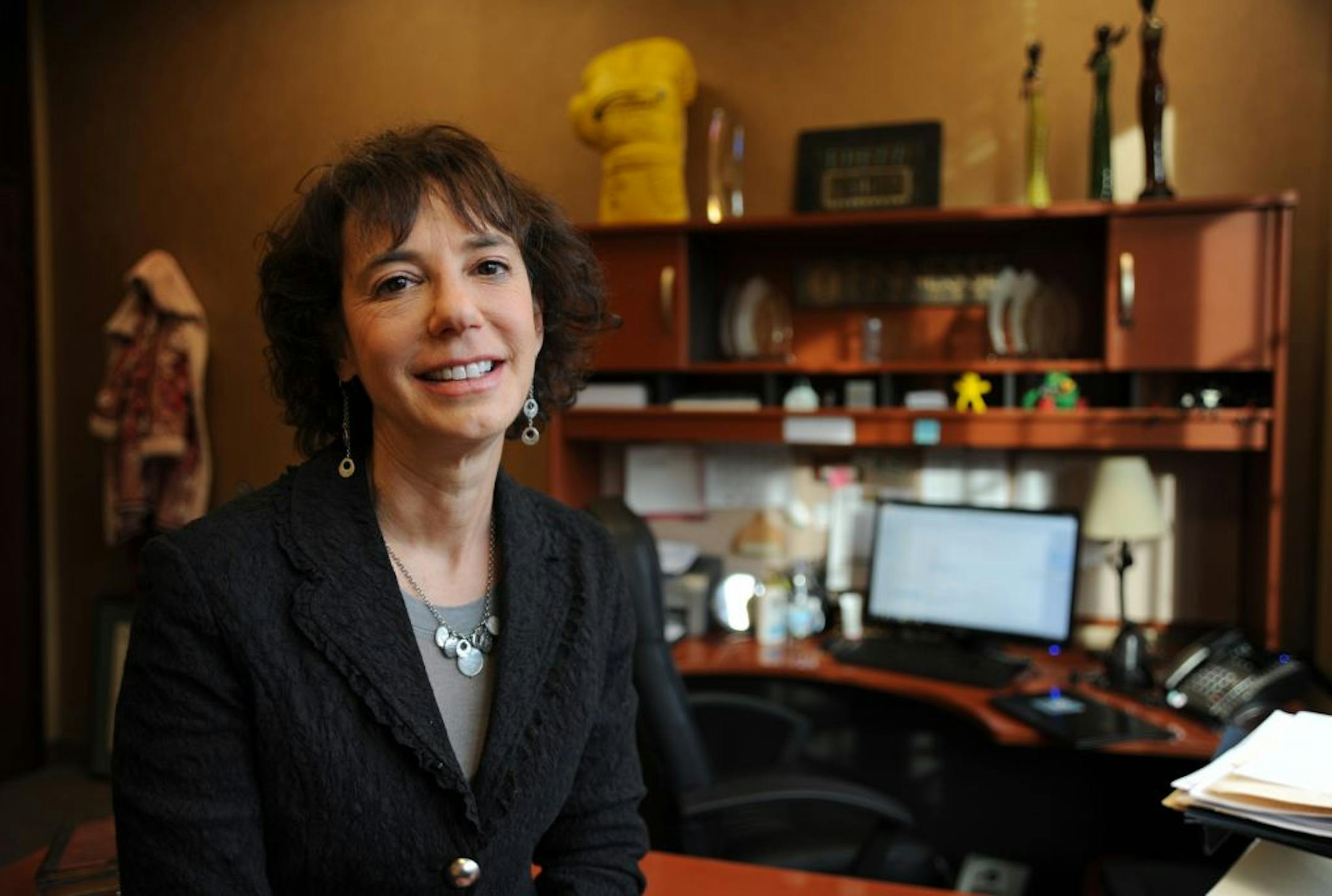 Janie Finn, sits on top of her desk on the second floor of Voyager Bank building in Minnetonka on Wednesday afternoon November 14,2012.She didn't have to leave the corporate world to launch Finnesse Partners, her Minnetonka-based recruiting firm that focuses on hiring for medical device companies. Instead, Finn got into business when her long-time corporate employer, publicly traded global recruiting firm Hudson, pulled out of Minnesota but left her to continue serving clients, freeing her from