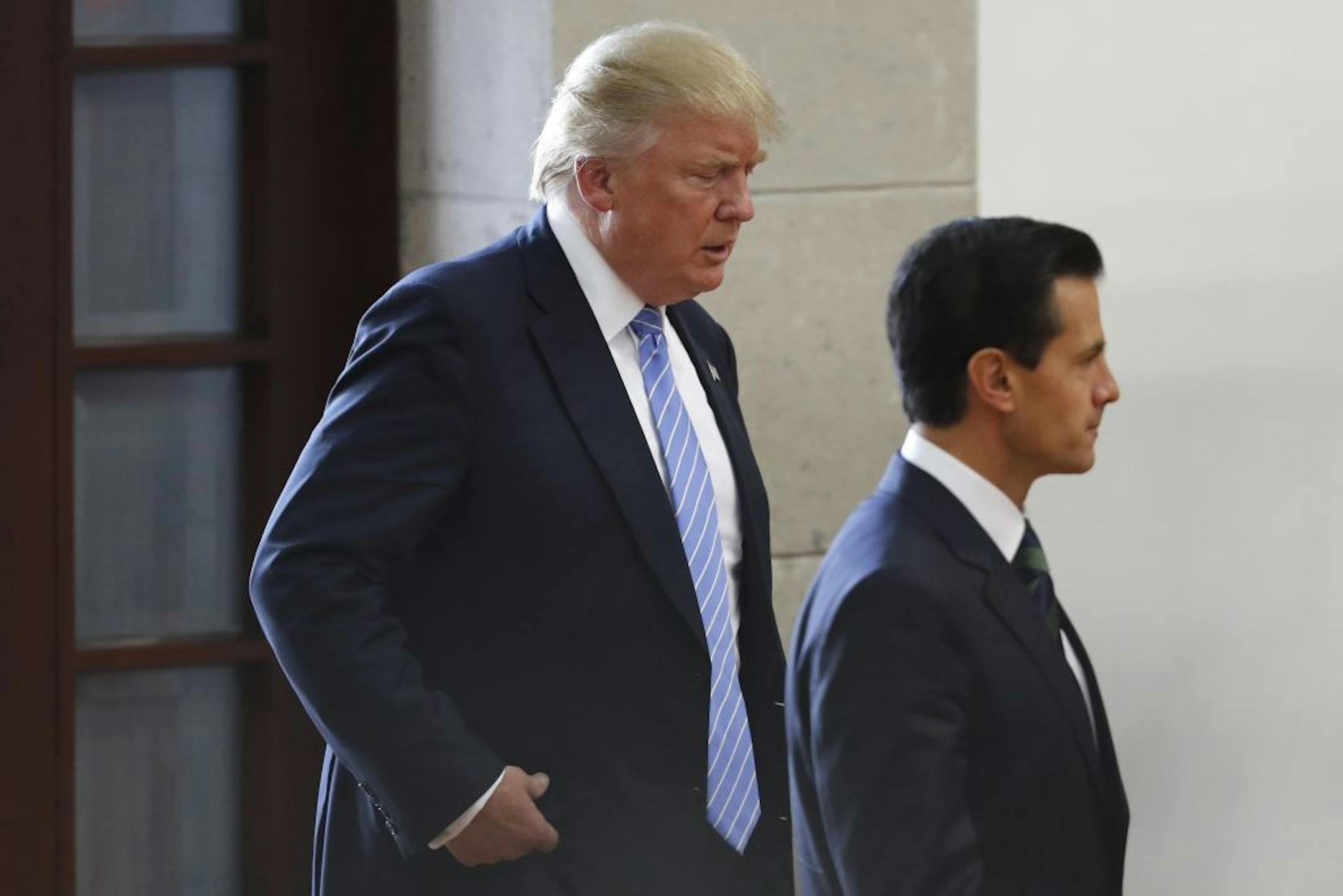 Republican presidential nominee Donald Trump, left, walks behind Mexico's President Enrique Pena Nieto as they arrive to deliver statements to the press in Mexico City, Wednesday, Aug. 31, 2016. Trump is calling his surprise visit to Mexico City a 'great honor.' The Republican presidential nominee said after meeting with Pe�a Nieto that the pair had a substantive, direct and constructive exchange of ideas.