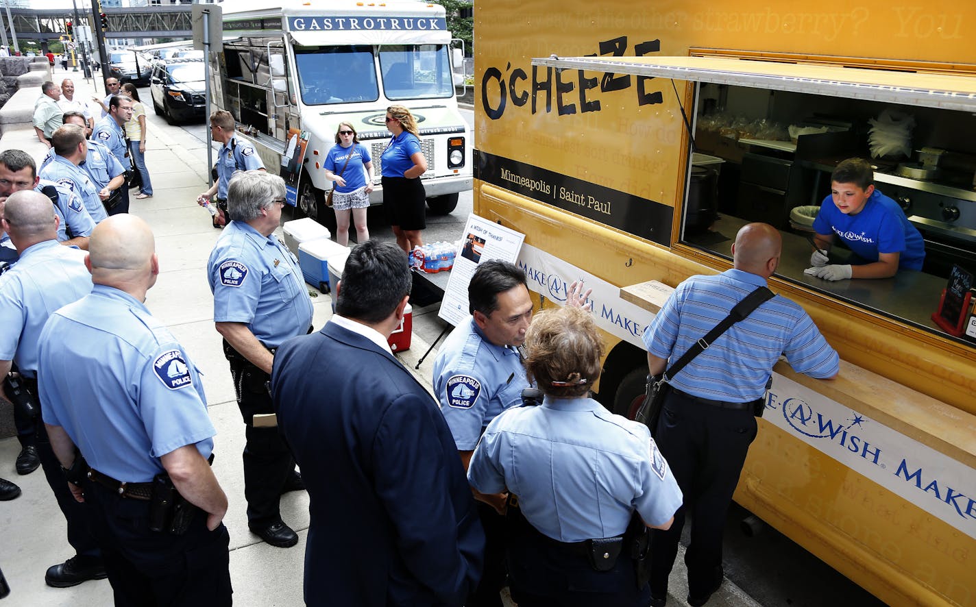 Lucas Hobbs, 12, took an order from a Minneapolis Police officer in front of City Hall. Hobbs, 12, was diagnosed with Stage 3 Hodgkin's Lymphoma. Hobbs wish was to feed police officers and with help of Make-A-Wish he was able to that on Monday at Minneapolis City Hall. Hobbs is currently in remission and may want to serve in law enforcement one day. ] CARLOS GONZALEZ cgonzalez@startribune.com - July 20, 2015, Minneapolis, MN, Lucas Hobbs, 12, was diagnosed with Stage 3 Hodgkin's Lymphoma. Hobbs