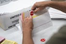 Todd Gallagher prepares mail in ballot envelopes including an I Voted sticker Wednesday, July 29, 2020 in Minneapolis. Absentee ballots are being requ