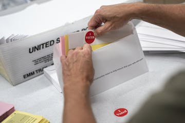 Todd Gallagher prepares mail in ballot envelopes including an I Voted sticker Wednesday, July 29, 2020 in Minneapolis. Absentee ballots are being requ