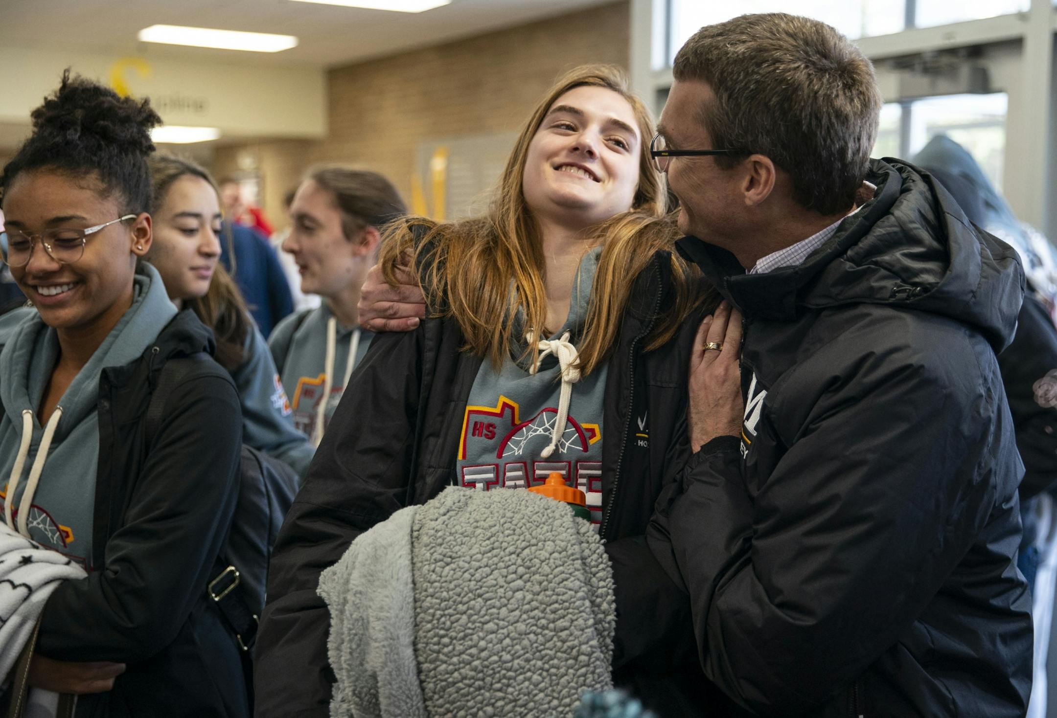 Duluth Marshall girl's basketball center Maren Friday was embraced by her father, Brett, after returning to school Friday afternoon following the cancelation of the MSHL girl's basketball tournament.