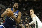 Minnesota Timberwolves' Karl-Anthony Towns, left, drives past Milwaukee Bucks' Donte DiVincenzo during the second half of a preseason NBA basketball g