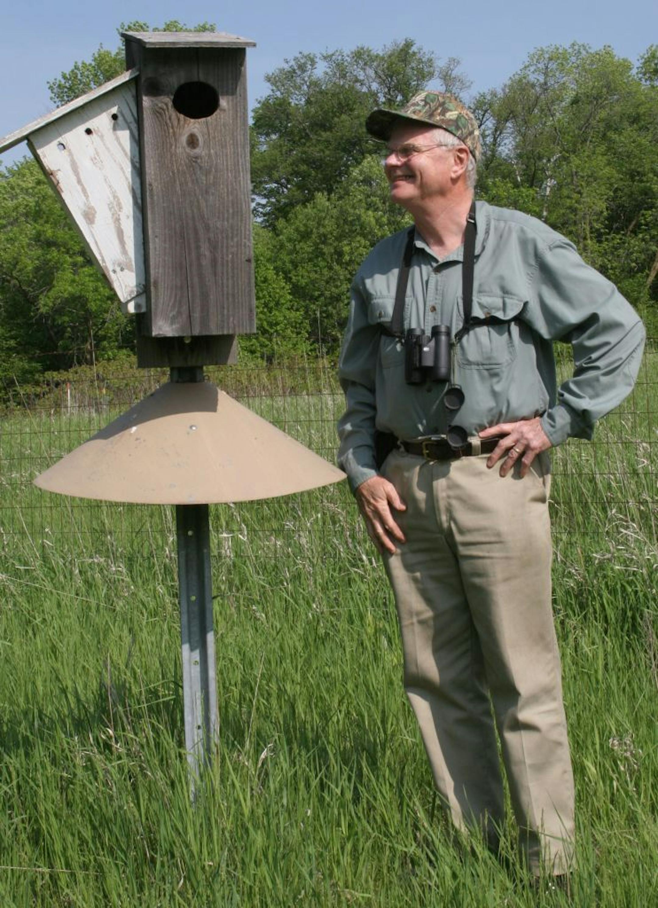 Dr. Roger Strand and one of his wood duck boxes, with a predator guard. Photo by Carrol Henderson, DNR