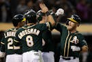 Oakland Athletics' Chris Herrmann, right, celebrates after hitting a grand slam off Minnesota Twins' Jake Odorizzi in the fourth inning of a baseball 