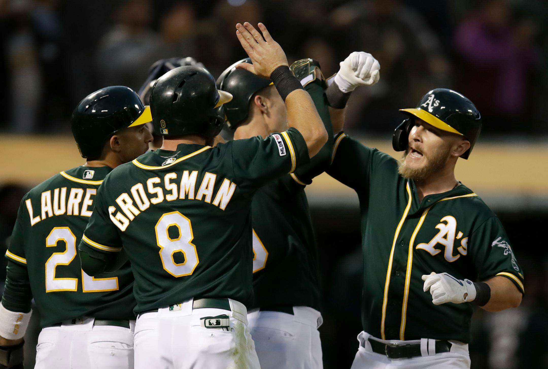 Oakland Athletics' Chris Herrmann, right, celebrates after hitting a grand slam off Minnesota Twins' Jake Odorizzi in the fourth inning of a baseball game Tuesday, July 2, 2019, in Oakland, Calif. (AP Photo/Ben Margot)