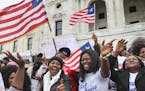 Hundreds of Twin Cities Liberians, including Evely Jarbatt (Center), gathered on the steps of the state Capitol for a rally in support of extending a 