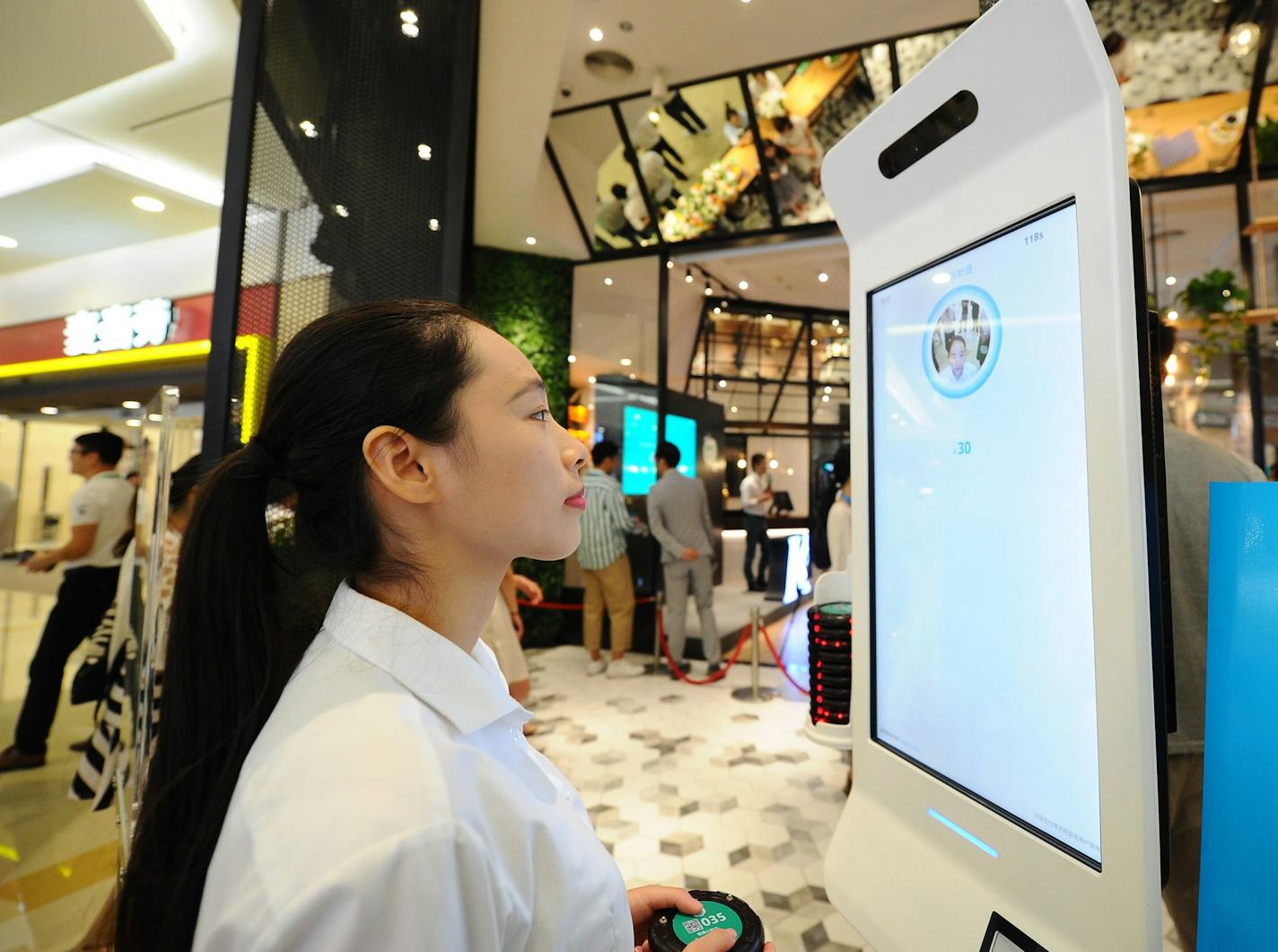 A customer looks at an ordering machine with the function of ordering food and facial recognition payment in KFC's first KPRO restaurant in Hangzhou city, east China's Zhejiang province, 31 August 2017. KFC opened its first KPRO restaurant in Hangzhou city, east China's Zhejiang province, 31 August 2017. KPRO sells fresh juice, beer, paninis and salads that can be topped with grilled chicken breast, South American white shrimp or smoked salmon. The integration of ''Smile to Pay'' in the new KPRO