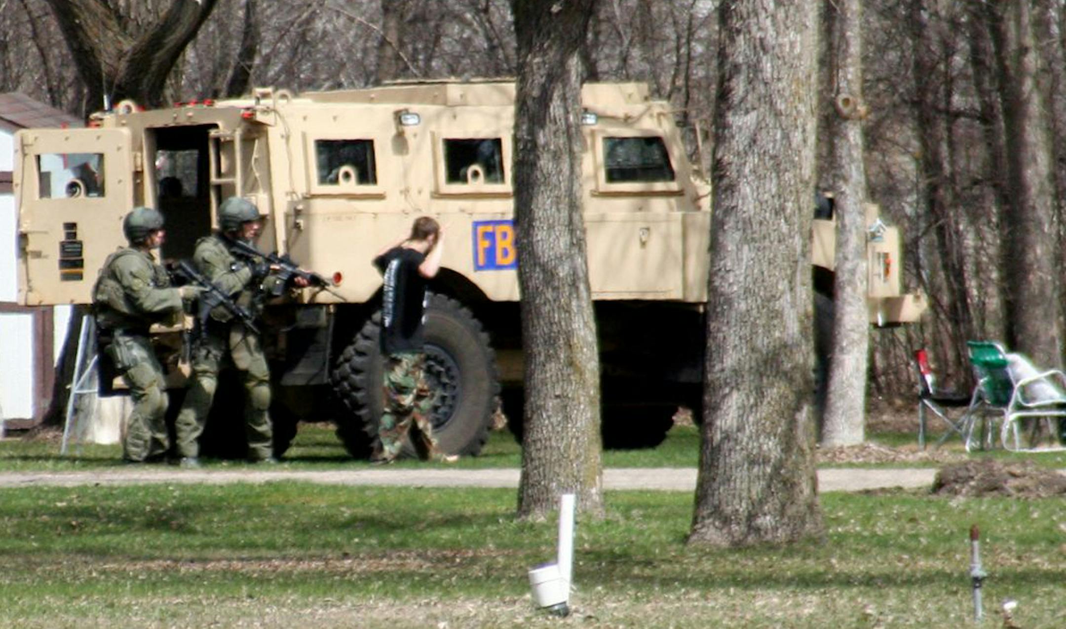 Authorities arrest Buford Rogers, right, during a raid on a mobile home in Montevideo, Minn.