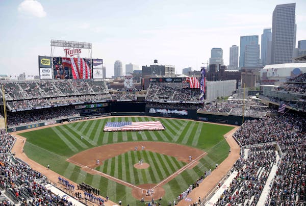 FILE - In this June 30, 2013 file photo, members of the Armed Forces hold a large flag at Target field in Minneapolis where the Minnesota Twins hosted