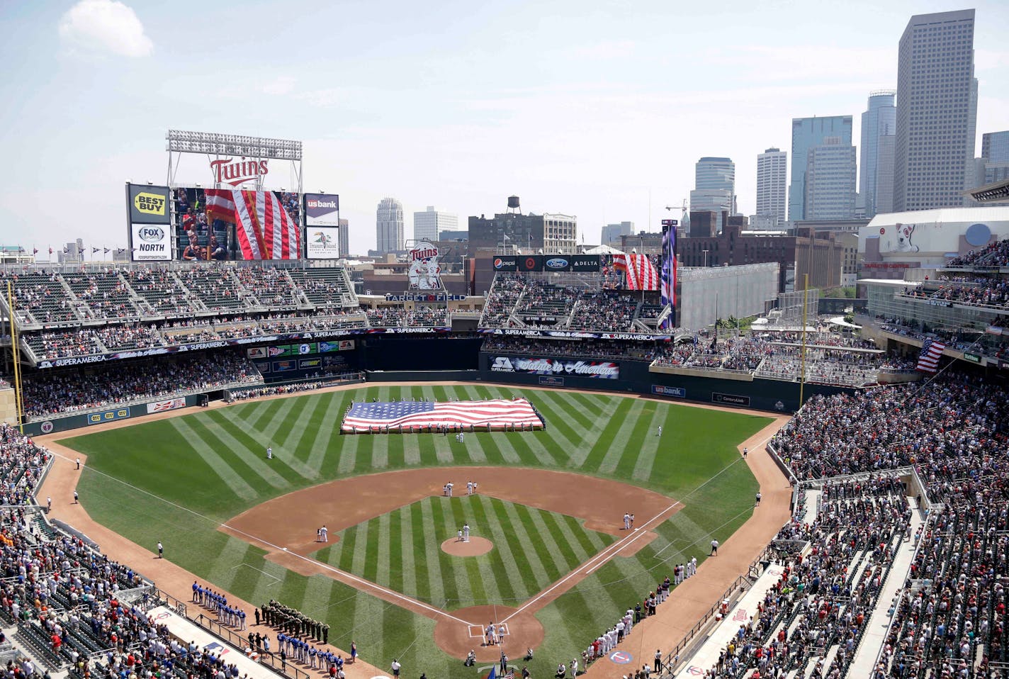 FILE - In this June 30, 2013 file photo, members of the Armed Forces hold a large flag at Target field in Minneapolis where the Minnesota Twins hosted Armed Forces Appreciation Day prior to the baseball game between the Twins and the Kansas City Royals. Major League Baseball's All Star festivities will be held in the 4-year-old ballpark, the one that helped outdoor baseball make a return to chilly Minnesota. (AP Photo/Jim Mone, File)