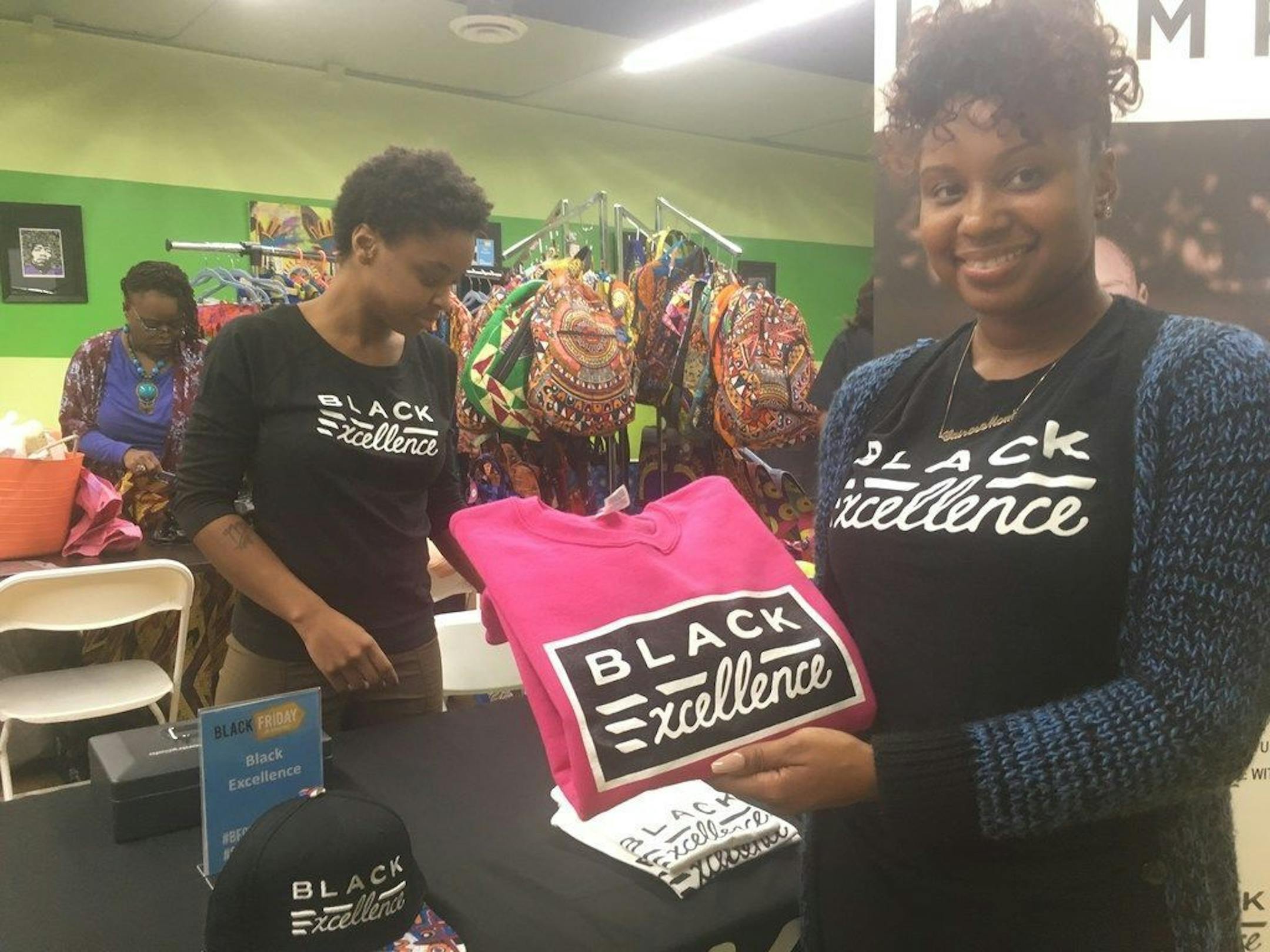 Eshay Brantley (left) and Nakara White (right) staffed clothing designer/retailer Houston White's booth at 2017's Black Friday on Broadway sale. Northside entrepreneurs are hoping to keep holiday shoppers closer to home this weekend. Star Tribune photo by Neal St. Anthony.