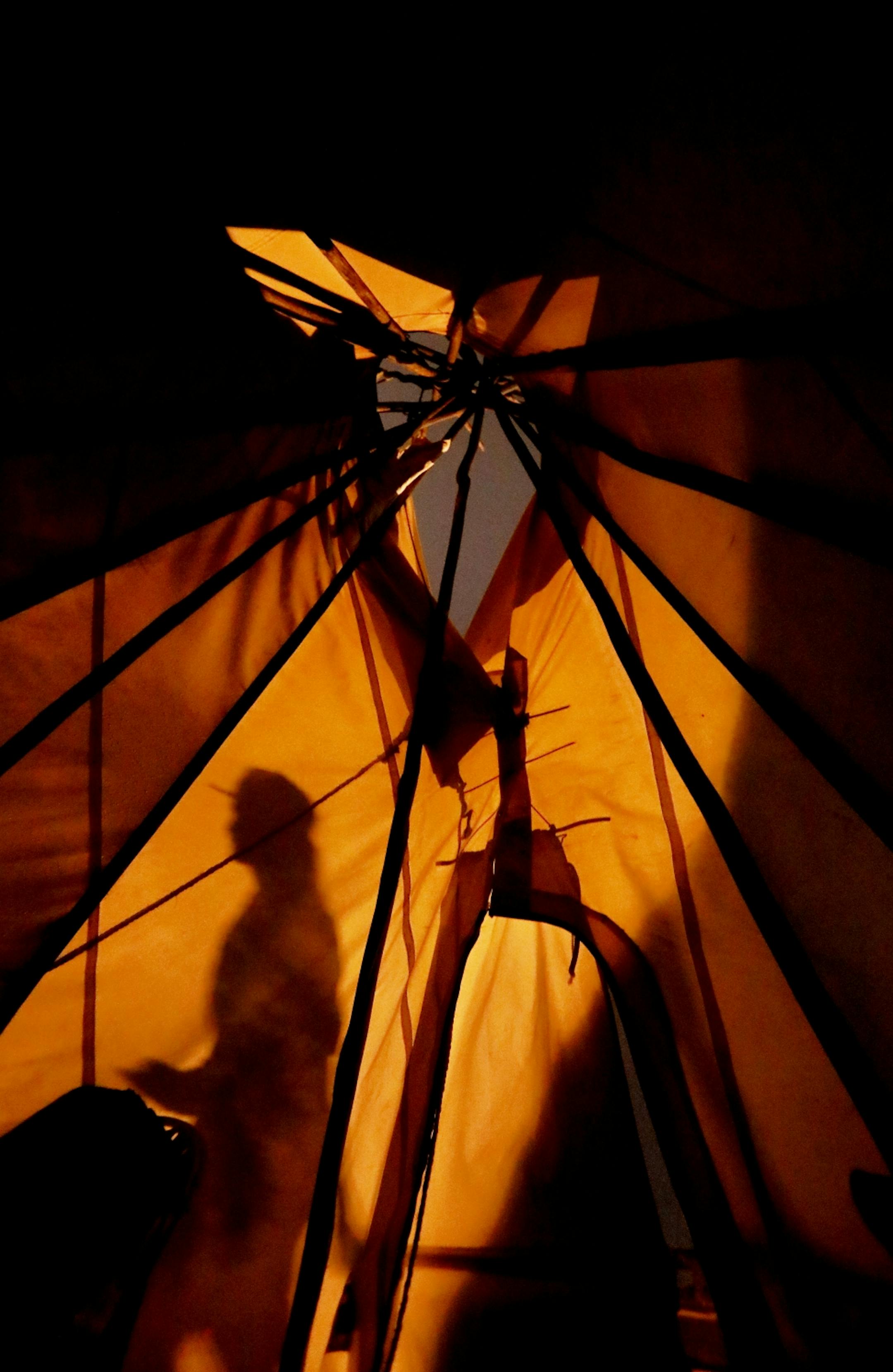 A shadow of a resident in a large homeless encampment is visible on the side of a teepee Thursday, Oct. 4, 2018, in Minneapolis, MN.