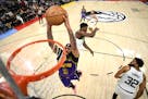Los Angeles Lakers forward Anthony Davis (3) dunks the ball against Minnesota Timberwolves guard Anthony Edwards (1) and center Karl-Anthony Towns (32