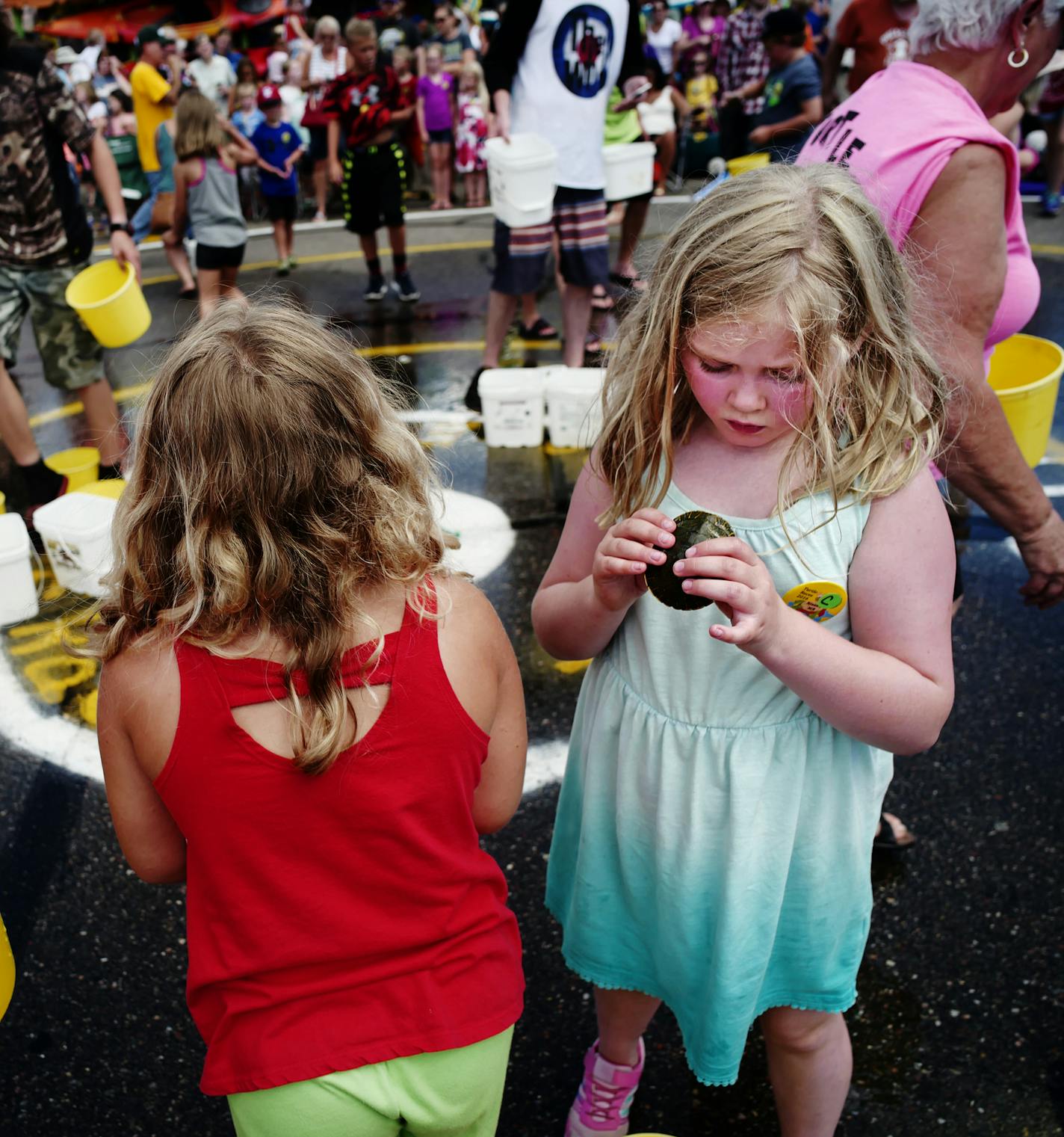 Darcy Wolf,7, of Bloomington, right, took a minute to enjoy her painted turtle after she was eliminated from a race heat..]For 53 years, visitors to the resorts in the Brainerd area have gathered in the parking lot of the Nisswa Chamber of Commerce to take part in a summer tradition that has endured changing times, the rise of high-tech entertainment and animal rights backlash: turtle racing.Richard Tsong-taatarii@startribune.com