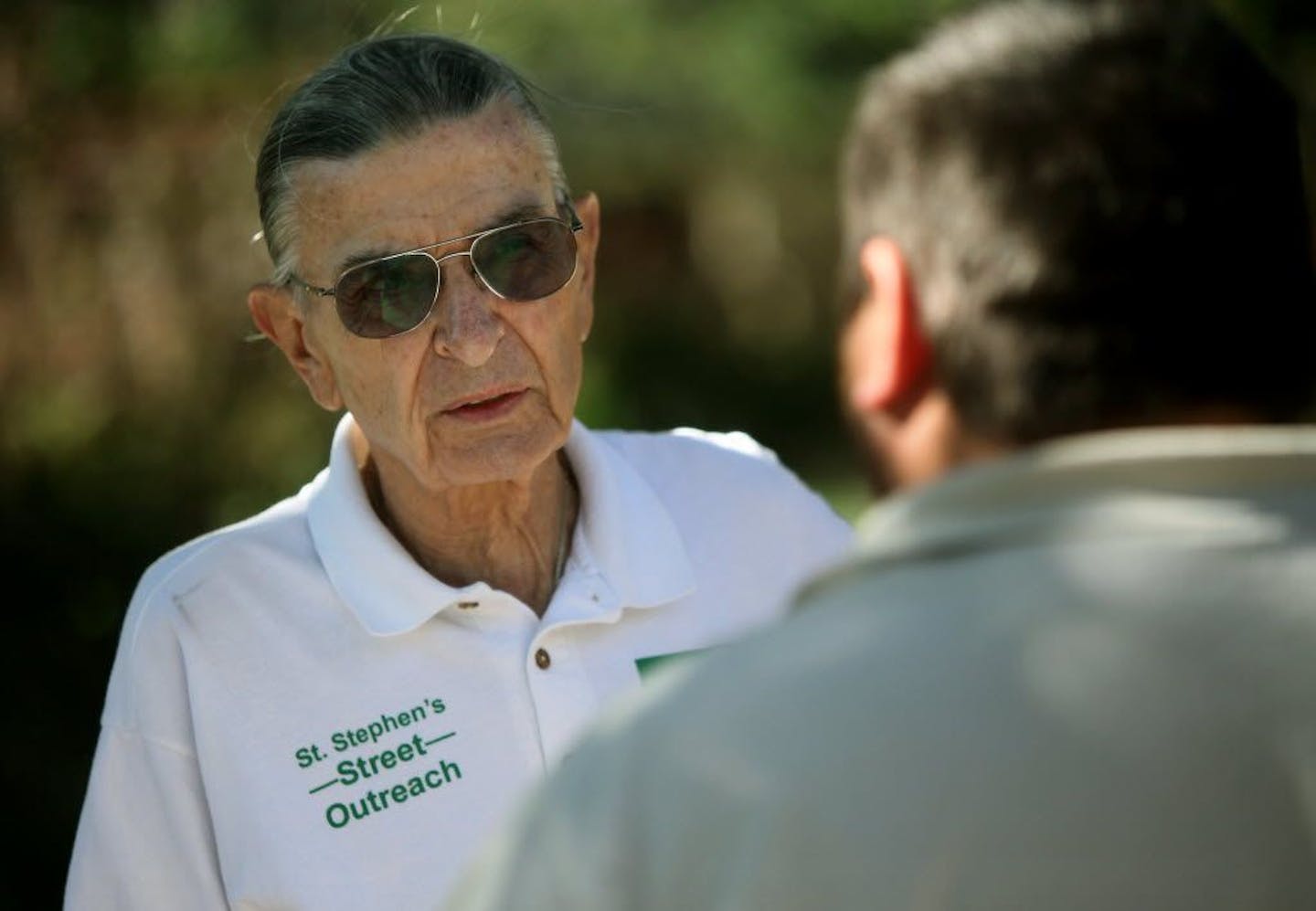 Jerry Fleischaker talked with a homeless man as he handed out St. Stephen pamphlets with resource information for the homeless at Peavey Plaza in downtown Minneapolis in 2010.