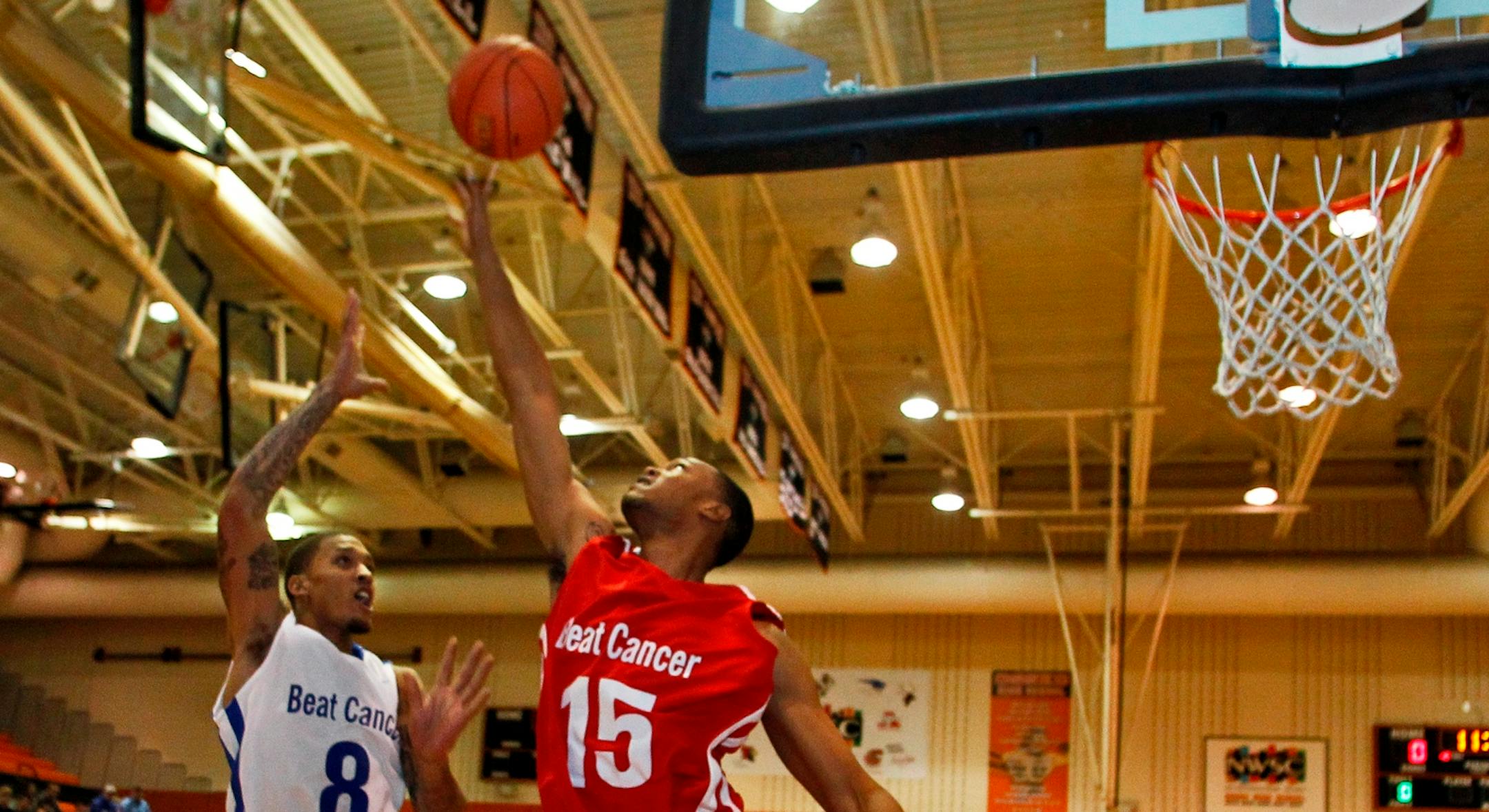 Michael Beasley's all-star basketball game with NBA players at Osseo High School. Anthony Toliver (15) blocked the layup attempt of Michael Beasley (8).