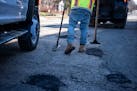 City of St. Paul workers patched potholes along 6th Street Friday in St. Paul. The lack of snow and warm weather this winter meant public works crews 