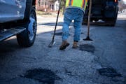 City of St. Paul workers patched potholes along 6th Street Friday in St. Paul. The lack of snow and warm weather this winter meant public works crews 