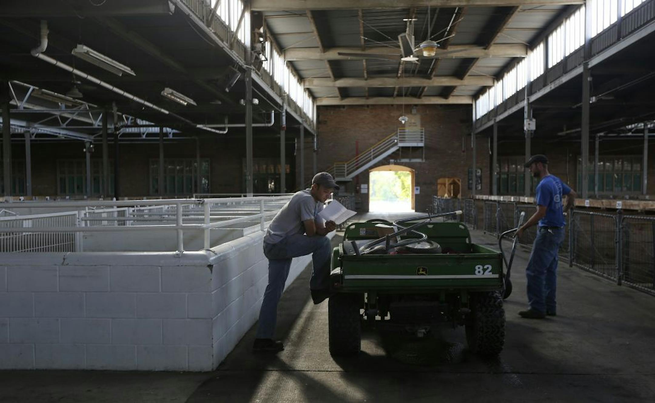 In the Swine Barn at the State Fairgrounds on Monday, Tony Marthaler, 20, left, and Joe Donnelly, 26, discussed where the scales for weighing pigs should be set up.