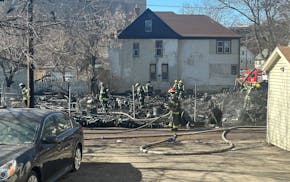 Fire personnel work to put out a fire near the 1100 block of E. 28th St. in Minneapolis on Thursday.