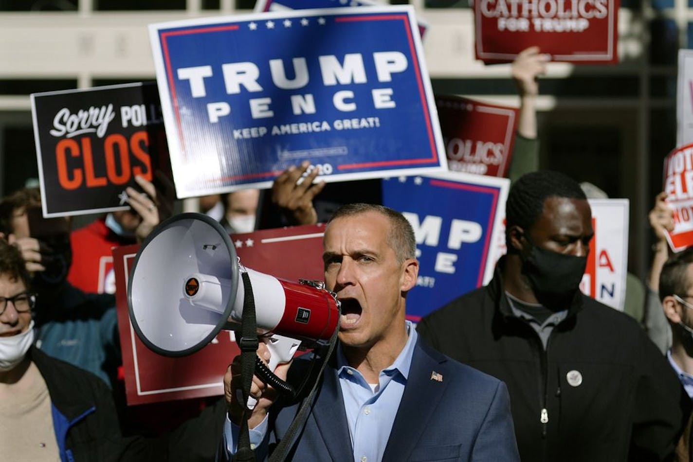 President Donald Trump's campaign advisor Corey Lewandowski, center, speaks about a court order obtained to grant more access to vote counting operations at the Pennsylvania Convention Center, Thursday, Nov. 5, 2020, in Philadelphia, following Tuesday's election.